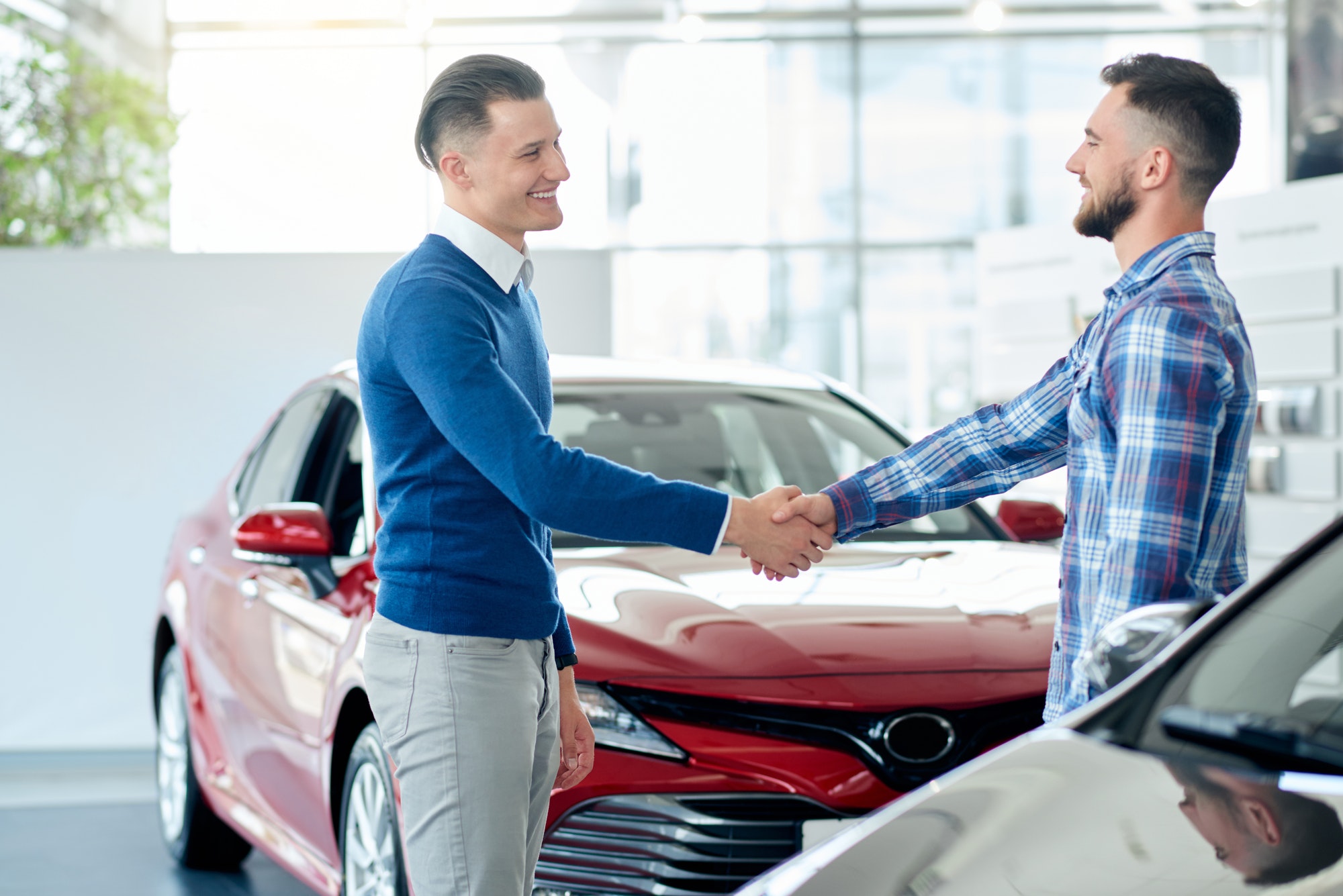 car-seller-and-customer-handshake-in-car-dealership.jpg